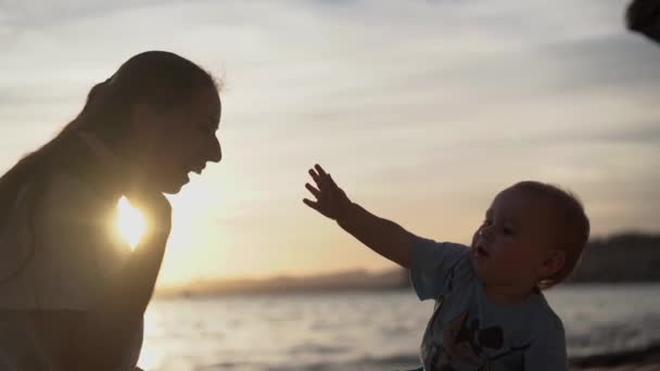 Glad tjej ger hög-fem till barnet vid solnedgången i slow motion — Stockvideo