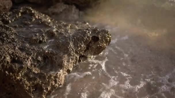 Морская волна приближается к камню в замедленной съемке — стоковое видео