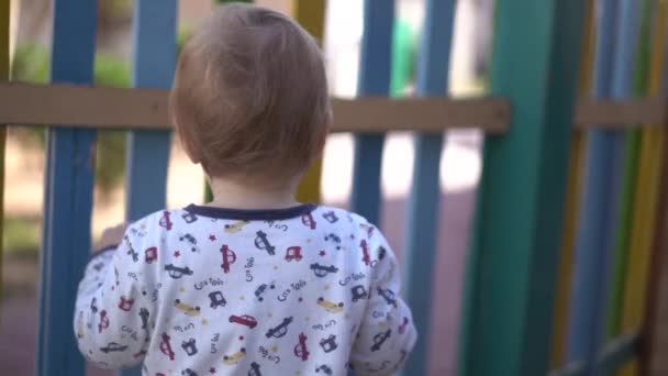 Niño mirando por encima de la valla en cámara lenta — Vídeos de Stock