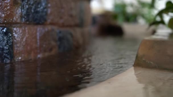 Woda spływa kamienną ścianę w ozdobnej fontannie w pokoju — Wideo stockowe