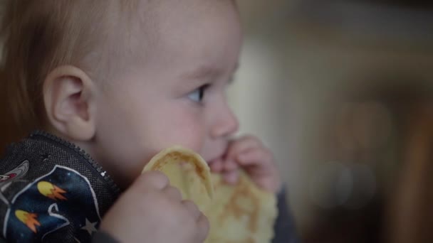 Маленький хлопчик їсть млинець крупним планом у повільному русі — стокове відео