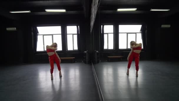 Sexy chica rubia baila en el estudio cerca del espejo . — Vídeo de stock