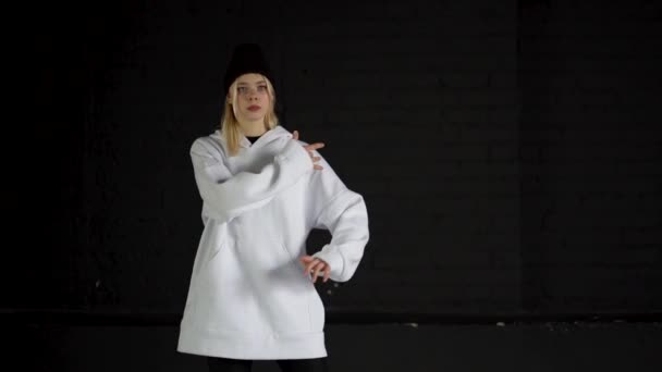 Mouvement lent de la fille qui danse hip hop en blanc habiller dans la chambre noire . — Video