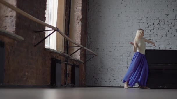 Блондинка танцівниця в синій спідниці робить розкол на одній нозі в повільному русі . — стокове відео