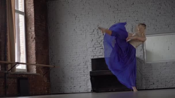 Amazing blonde dancer makes twine one one leg in blue skirt. — Stock Video