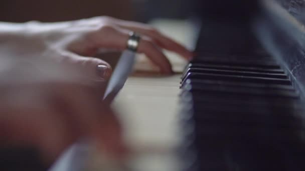 Slow motion - de vingers van het meisje spelen de piano toetsen. — Stockvideo