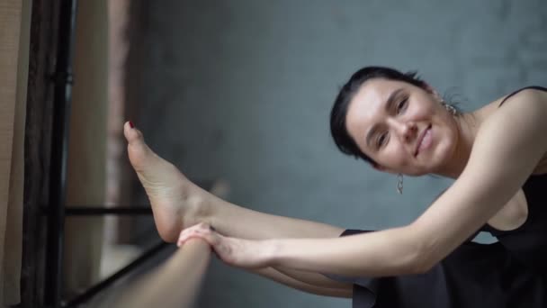 Señora en vestido negro estratando y sonriendo en cámara lenta . — Vídeos de Stock