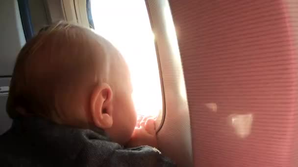 Ragazzino biondo guarda nella finestra di aereo furing volo . — Video Stock