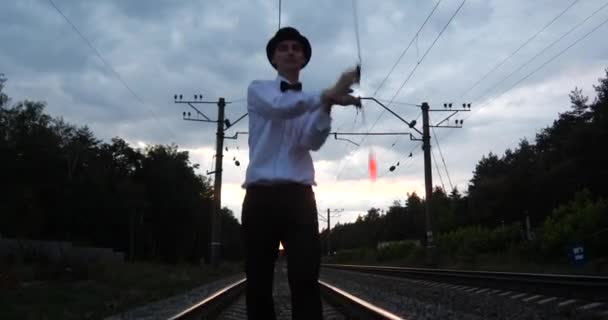 4k - Artista en traje de gentalman hace espectáculo en el ferrocarril . — Vídeos de Stock