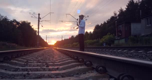 4k - artista gentalman faz truque na ferrovia ao pôr-do-sol . — Vídeo de Stock