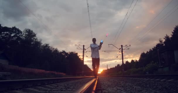 4k - artista gentil hace truco en el ferrocarril al atardecer . — Vídeos de Stock