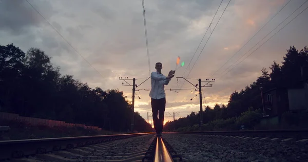 Gentalman kunstenaar maakt truc op het spoor bij zonsondergang. — Stockfoto