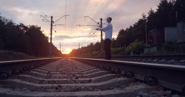 4K-gentalman artysta sprawia, że sztuczka na linii kolejowej o zachodzie słońca. Obraz Stockowy