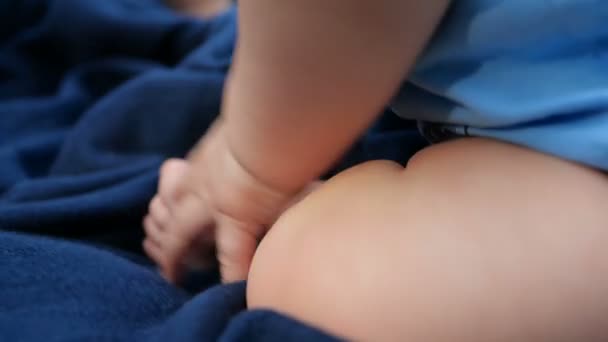 Alegre niños pies acostados en una sábana azul oscuro en un prado verde en slo-mo — Vídeos de Stock