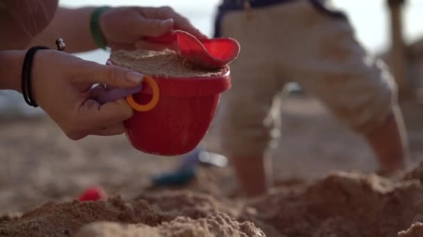 Handen van moeder afspelen hark met baby vertraagd. — Stockvideo