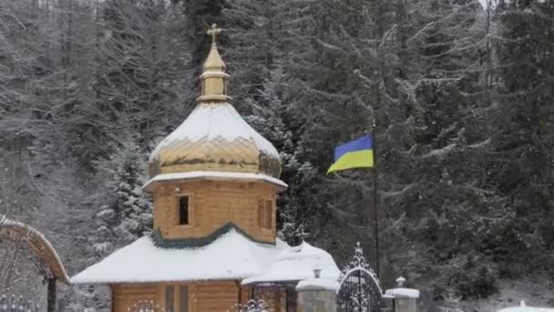Drewniany kościół prawosławny z ukraińską flagą w Karpatach — Wideo stockowe