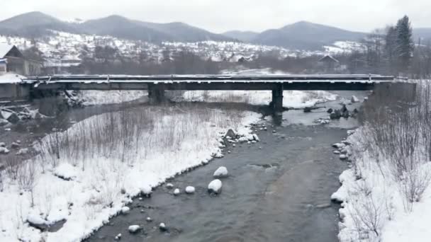 Úzká bystřka proudící pod mostem v Karpatech v zimě v slo-mo — Stock video