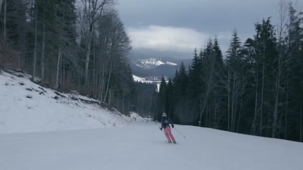 Professionele vrouw in uniforme skiën beneden in de Karpaten in de winter in slo-mo — Stockvideo