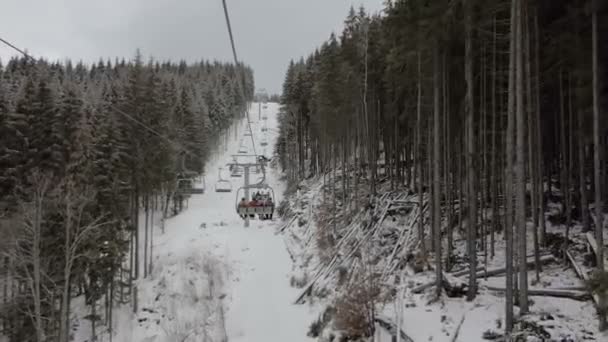 Happy tourists moving on a long ski lift in the Carpathians in winter in slo-mo — Stock Video