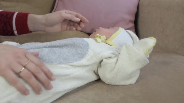 Мати з новонародженою дитиною сидить біля ялинки . — стокове відео