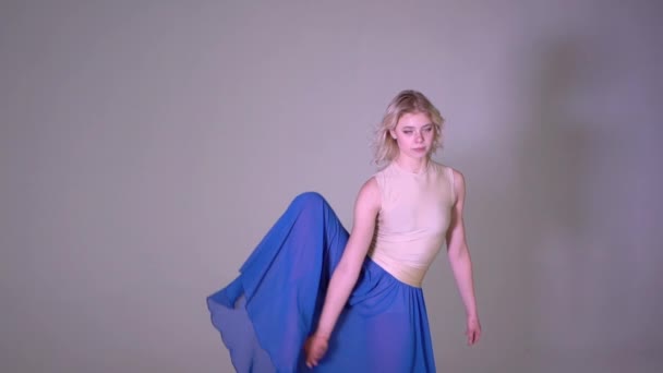 En blond tjej som gör en vertikal ben split i studio — Stockvideo