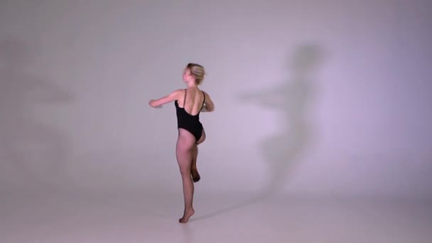 Attraktiva flicka utför professionellt pirouette i studio i slow motion — Stockvideo