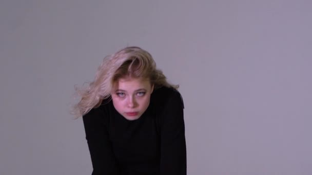 Молодая блондинка молча показывает пальцем на губах в замедленной съемке — стоковое видео
