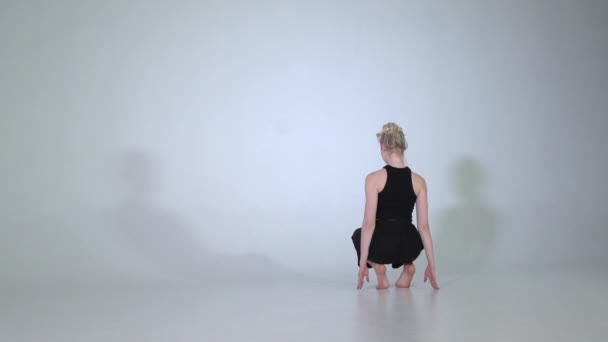 Девушка, занимающаяся гимнастикой в студии в замедленной съемке — стоковое видео