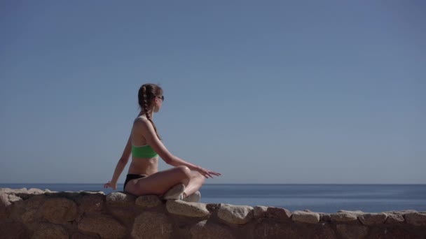 4k - Young and slender model makes yoga on the beach of the sea. — Stock Video