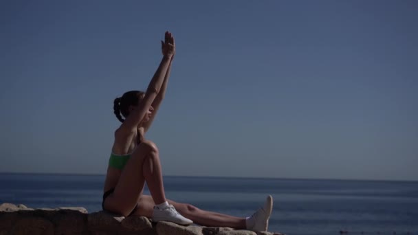 Сексуальна дівчина робить нахил йоги біля моря . — стокове відео
