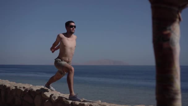 4k - мужчина практикует йогу на пляже . — стоковое видео