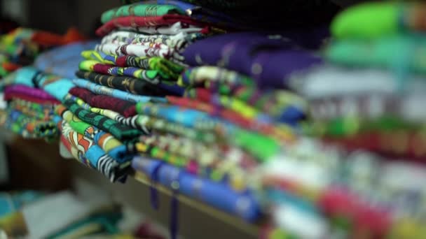 Gros plan d'un comptoir avec des vêtements multicolores soigneusement pliés . — Video