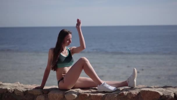 Σέξι μοντέλο κάνει γιόγκα στρίβοντας στην παραλία. — Αρχείο Βίντεο