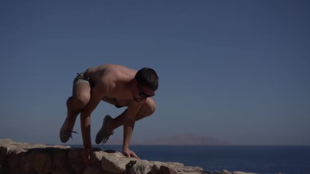 4k - el hombre se para en la mano y hace yoga pose grúa . — Vídeo de stock