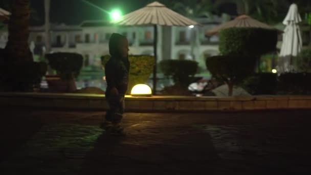 4k - bambino che cammina sulla strada dell'hotel di notte . — Video Stock