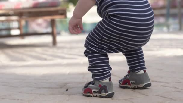 Primer plano de las piernas de los bebés que caminando en la calle . — Vídeo de stock