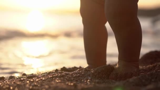 Cute close-up shot benen van de baby die staat op het strand. — Stockvideo