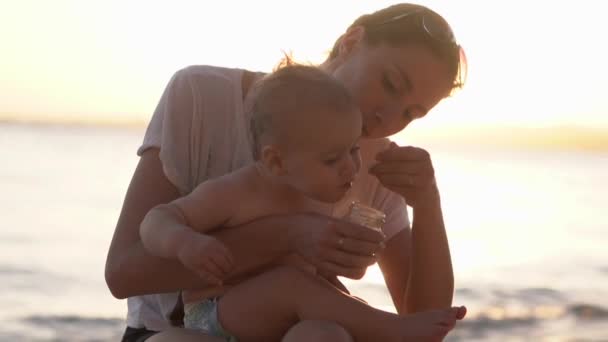 Mama karmi dziecko łyżeczką z słoika, a dziecko nie chce jeść — Wideo stockowe