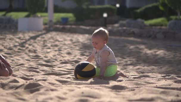 Ung mamma leker med sin bebis med bollen i slow motion. — Stockvideo