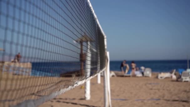 Centrándose en la red de voleibol en cámara lenta en la playa del mar . — Vídeos de Stock