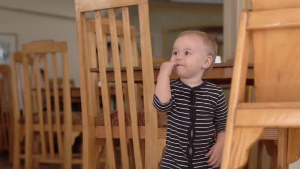 Malé děťátko s vtipnou tváří stojící v pomalém pohybu v kithcen. — Stock video