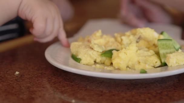 Il dito di un bambino viene raccolto nel porridge giallo — Video Stock