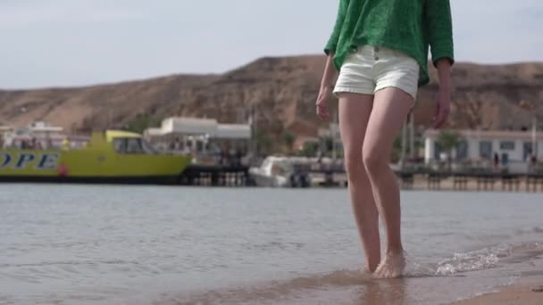 Sottili giovani donne gambe giocare con l'acqua al rallentatore sulla spiaggia . — Video Stock