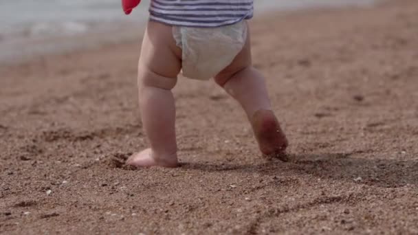 Una divertida corrida del niño en la playa con la pala en las manos. — Vídeos de Stock