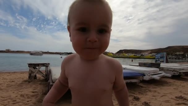 Das Kleinkind steht am Strand, bewegt sich in Zeitlupe zur Kamera — Stockvideo