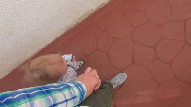 Ο μπαμπάς ηγείται από το χέρι ενός έτους γιου, θέα από πάνω σε αργή κίνηση — Αρχείο Βίντεο
