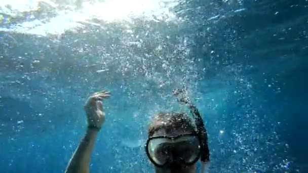 Ένας νεαρός τύπος βουτάει σε μια μάσκα κάτω από το νερό, μαγικό αφηρημένο υδάτινο φόντο — Αρχείο Βίντεο