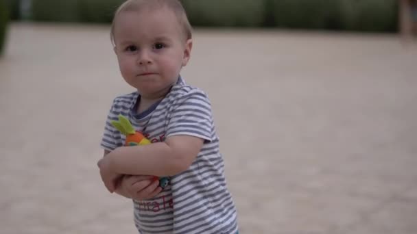 Biondo ragazzo camminare con il giocattolo coniglio in slow motion . — Video Stock