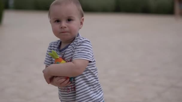 Blonder Junge läuft mit dem Spielzeughasen in Zeitlupe. — Stockvideo