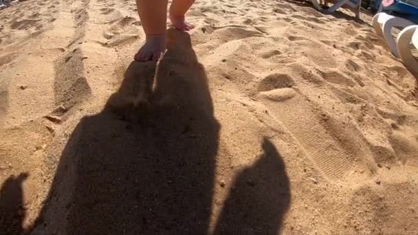 Cute shadow of the little kid that walks on the beach. — Stock Video